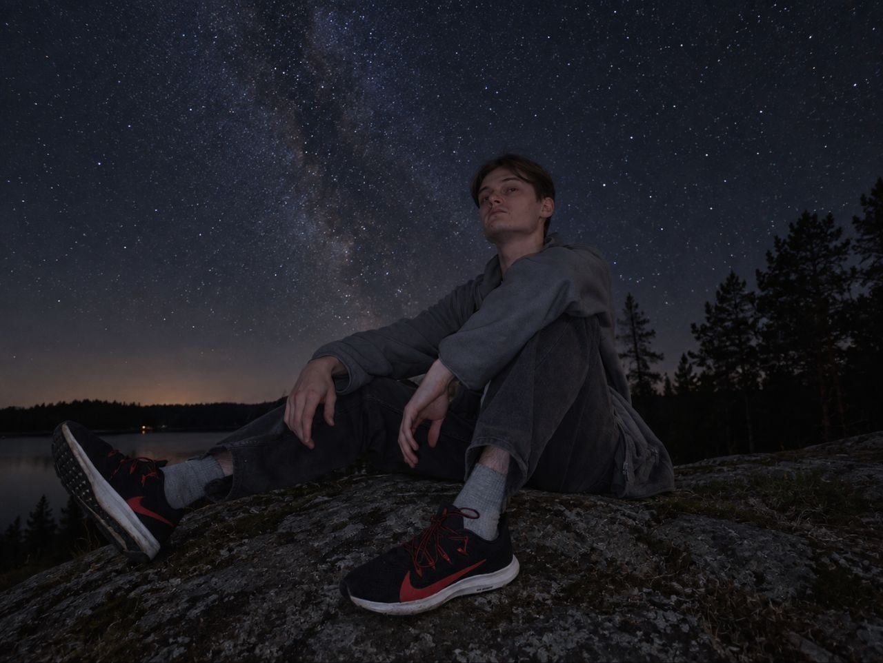 Nikita beside a lake under a starry sky